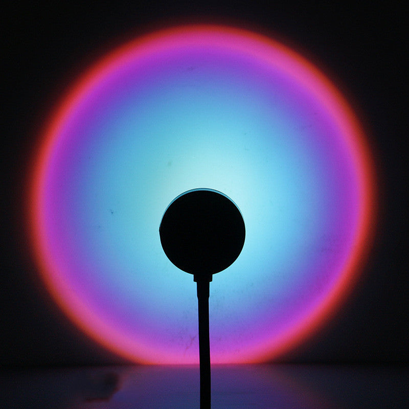 Sunset projection lamp casting a colorful glow of pink and blue, creating a cozy atmosphere for relaxation.