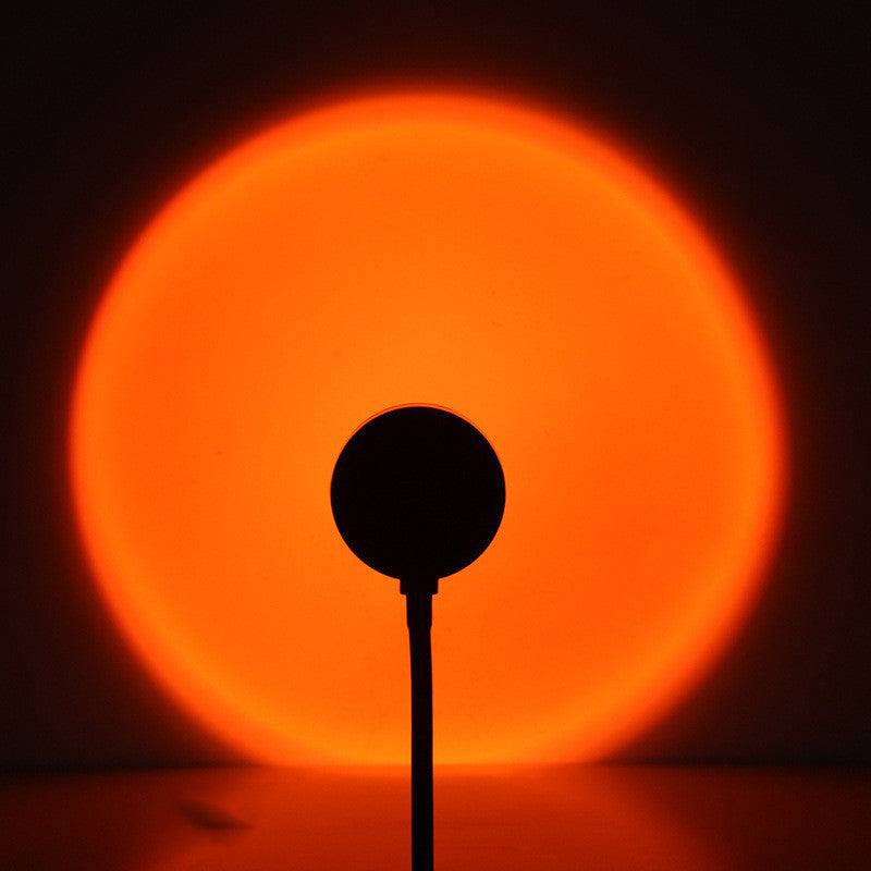 Sunset projection lamp casting warm orange light on a wall, creating a cozy and dreamy atmosphere.