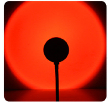 Sunset projection lamp casting warm colors, showcasing remote control and various light effects for cozy ambiance.