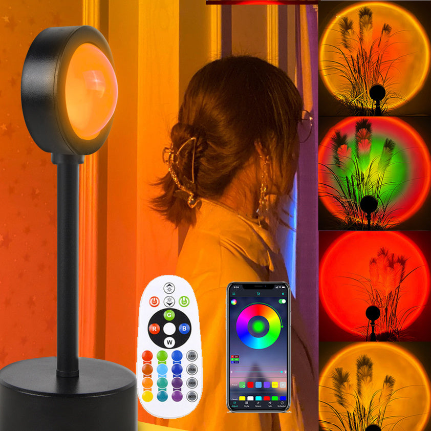 Sunset projection lamp casting warm colors, showcasing remote control and various light effects for cozy ambiance.